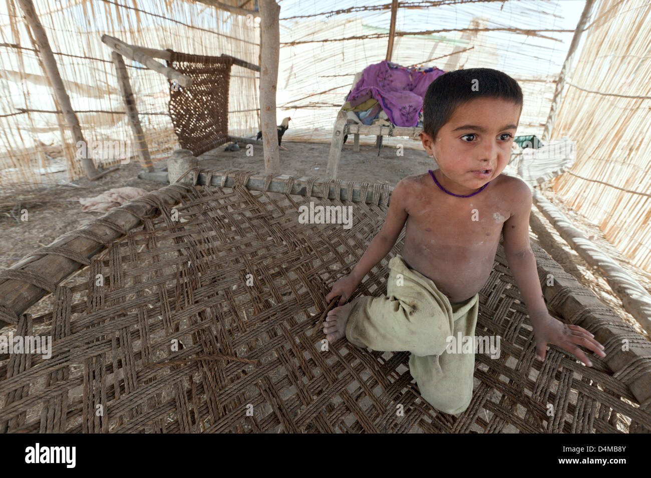 Jakrani Lujja Khan, Pakistan, le petit garçon assis sur son lit Banque D'Images