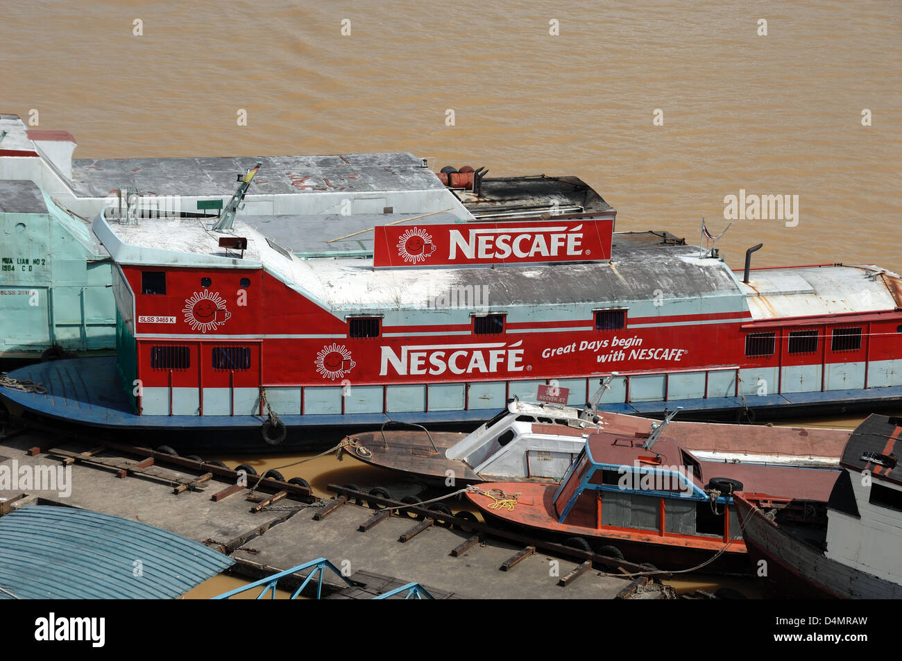 Bateaux traditionnels de la rivière en bois avec des annonces peintes Publicité Nescafé à Sibu sur le Rajang River Waterfront Sarawak Borneo Malaisie Banque D'Images