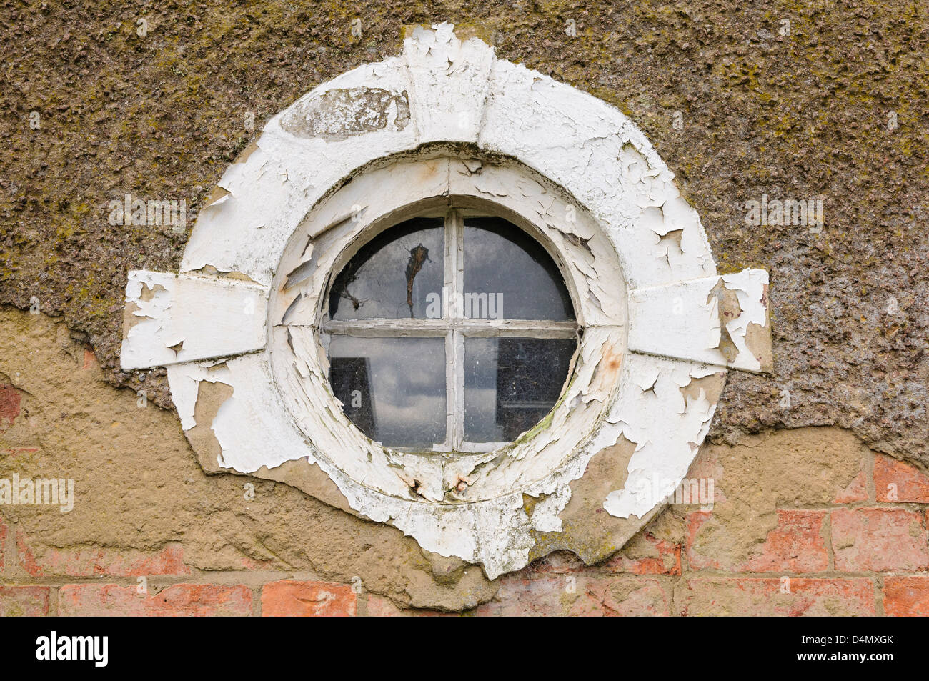 Vieux, fenêtre ronde, sur un mur avec du plâtre cassé Banque D'Images