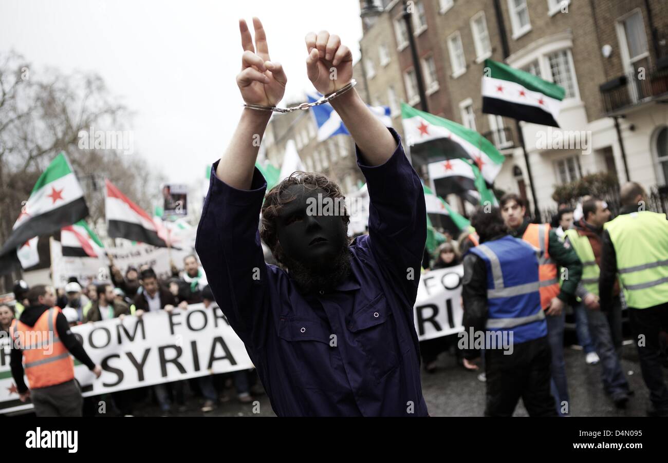 Londres, Royaume-Uni. 16 mars 2013. Un homme portant un masque et des menottes à la tête d'un des partisans de l'opposition syrienne mars mars à Londres aujourd'hui, tenu en solidarité avec le peuple de Syrie. Les membres de la manifestation scandaient contre Assad, l'ONU et de l'UK. George Henton / Alamy Live News. Banque D'Images