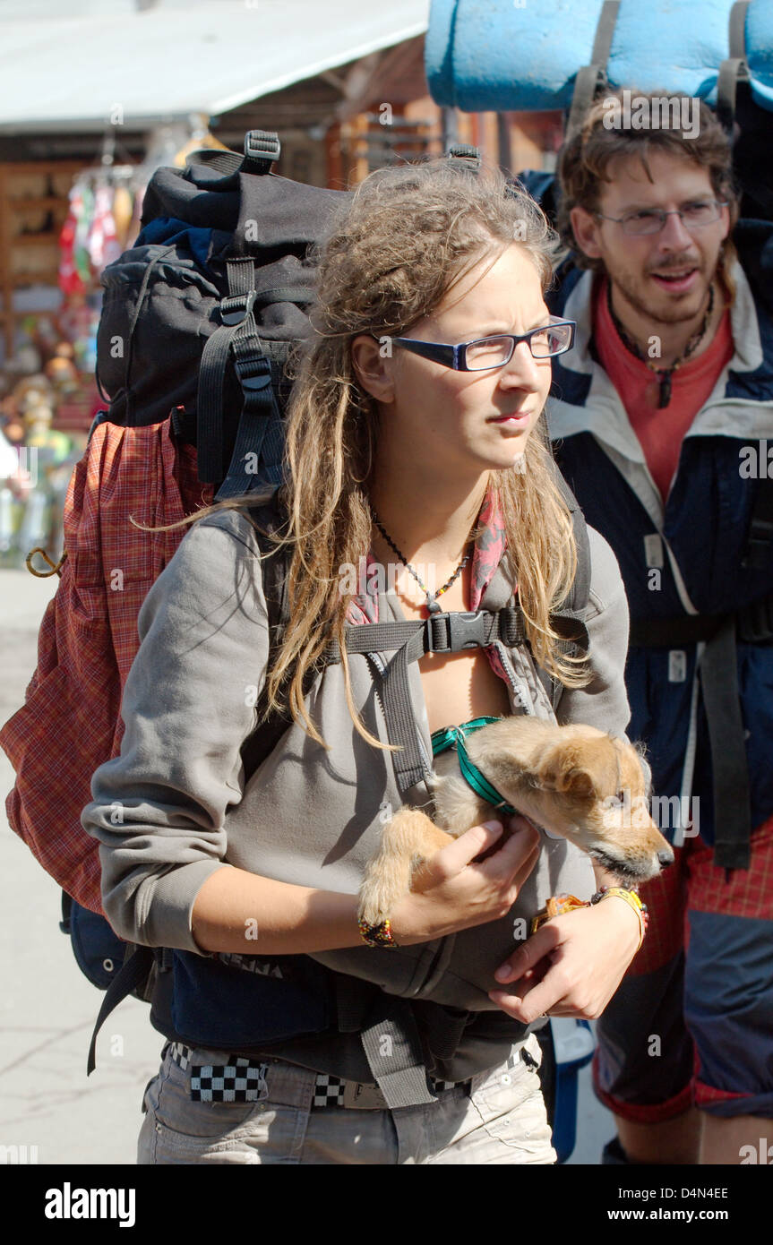 Une jeune femme avec un sac à dos est un chiot dans ses bras, Transylvanie, Roumanie, Brașov Banque D'Images
