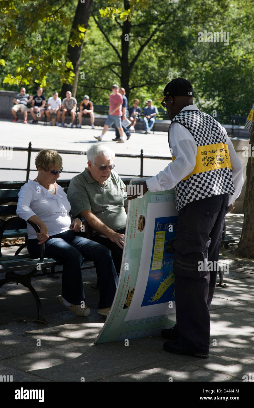 Un guide touristique en maintenant les touristes vous harcèlent un grand poster en face d'eux dans Central Park, New York Banque D'Images