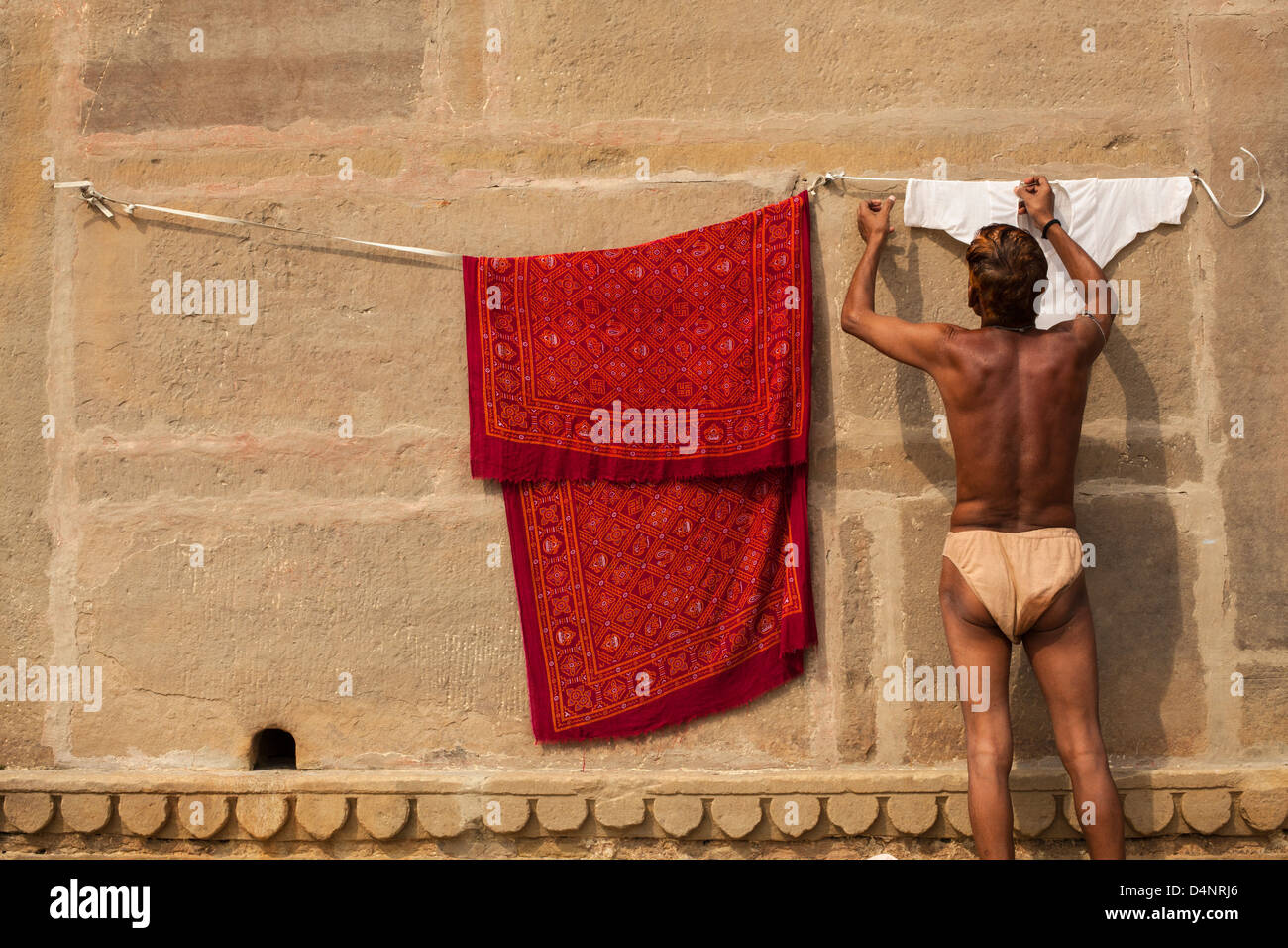 L'homme accroché au lavage, Varanasi, Inde Banque D'Images