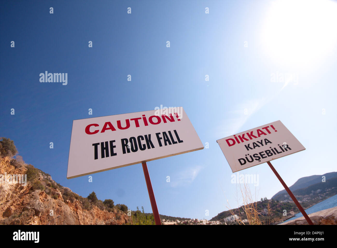 Un signe sur une plage à Kalkan, Turquie avertissement contre rock falls en anglais et en turc Banque D'Images