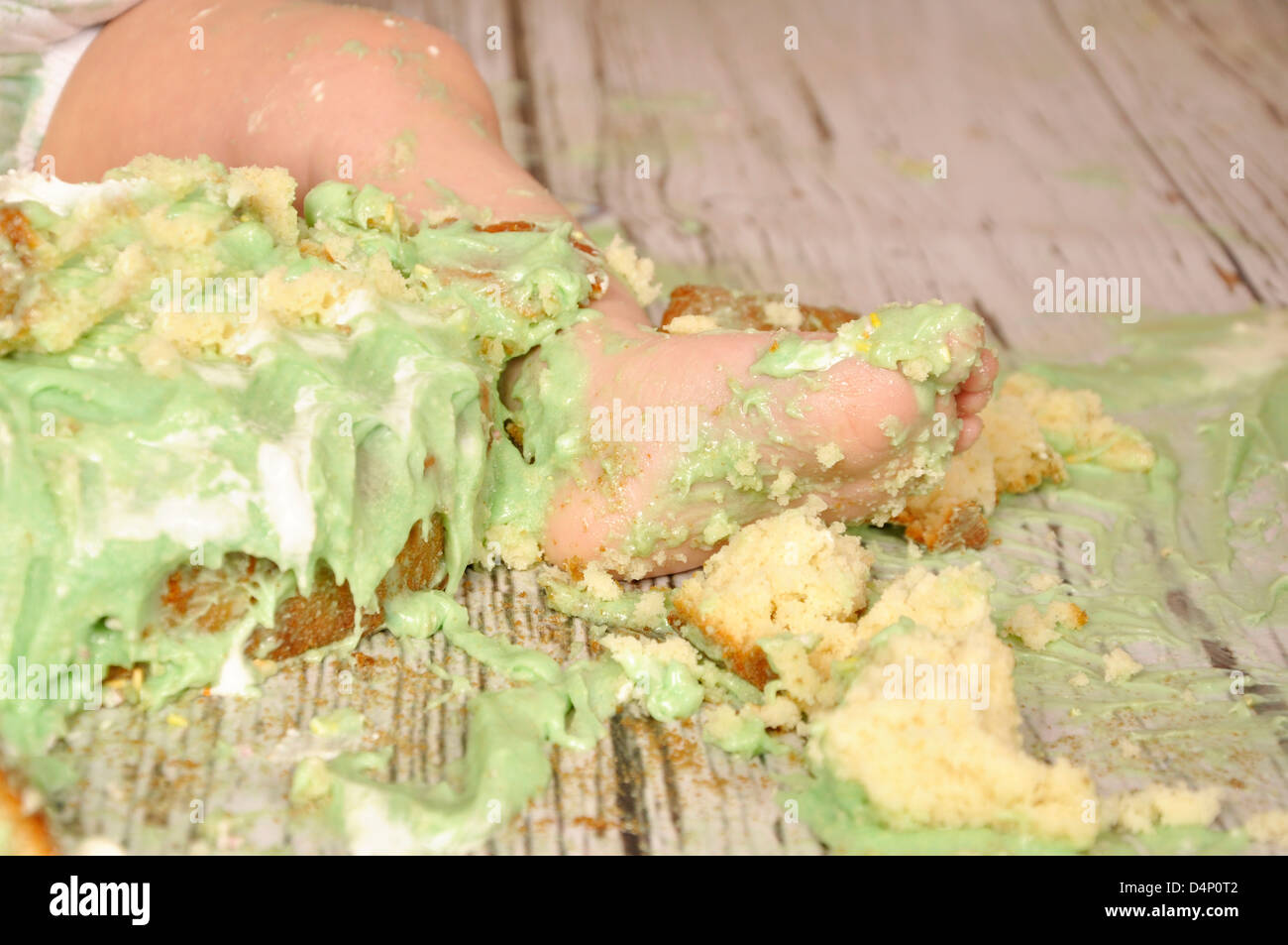 Les orteils du pied bébé gâteau sucré smash vert miettes malpropres mess gâteau glacer Banque D'Images