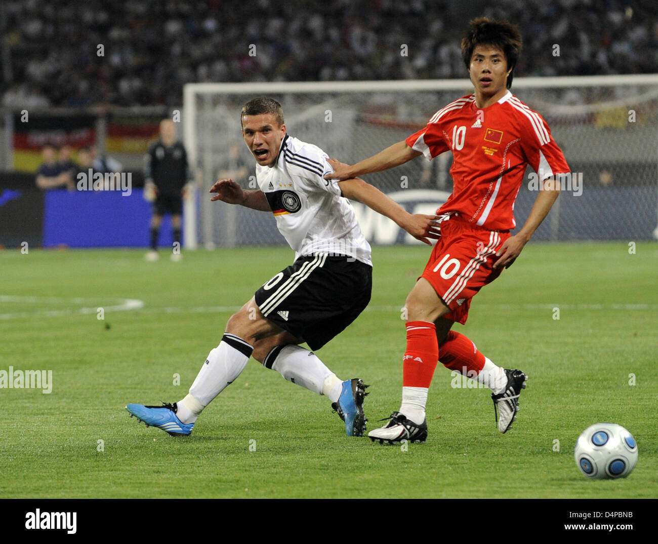 L'Allemagne ?s Lukas Podolski (L) convoite la la balle avec la Chine ?s au cours de la Villa 16 Hao football match international de la Chine contre l'Allemagne au Stade de Shanghai à Shanghai, Chine, 29 mai 2009. Photo : MARCUS BRANDT Banque D'Images