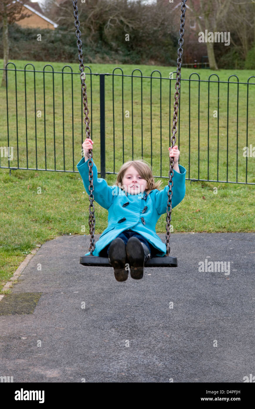 8 ans fille s'amusant à jouer sur la balançoire dans un parc à Bristol, Royaume-Uni Banque D'Images