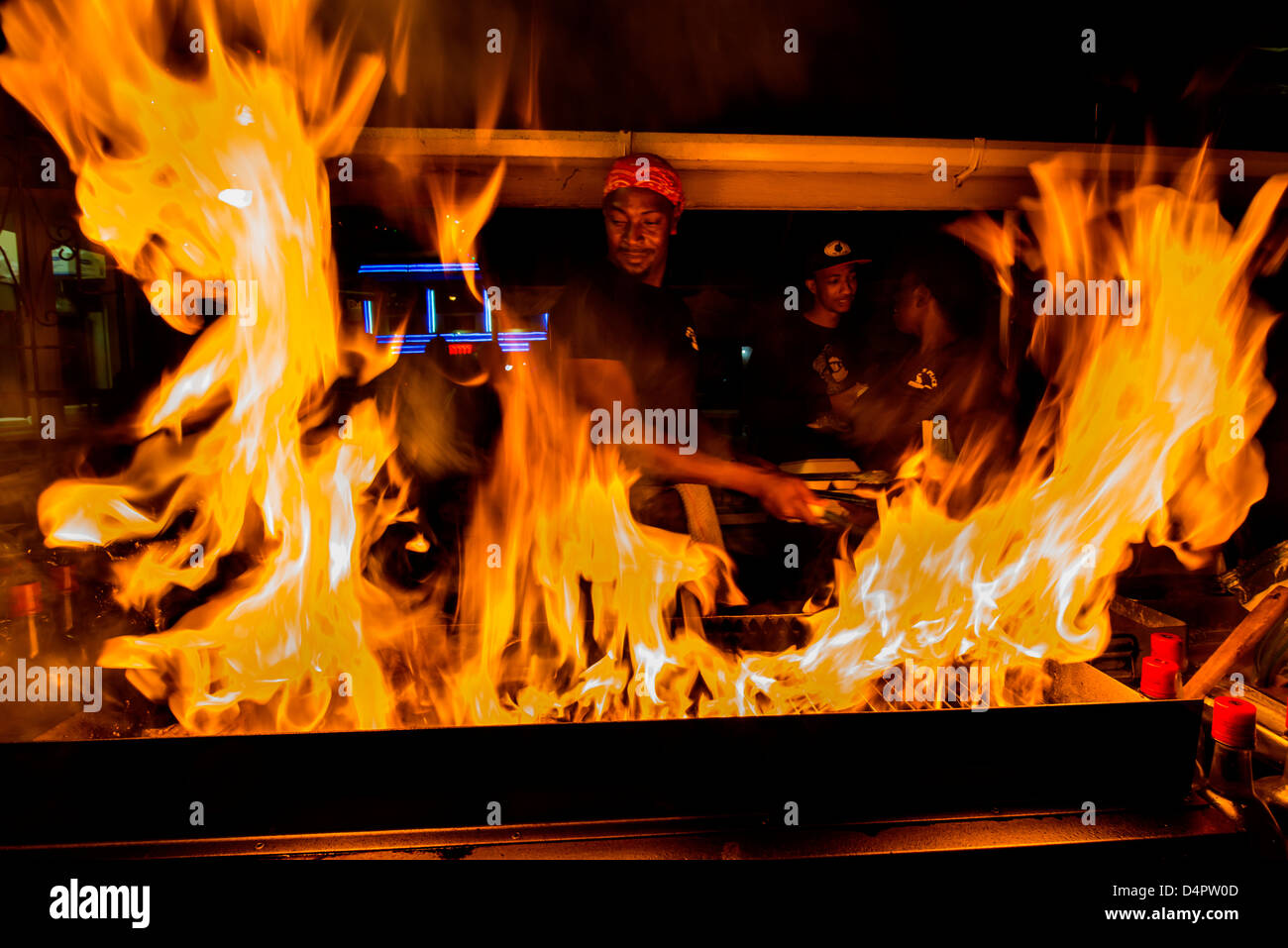 Un homme de la friture du poisson sur un barbecue à Oistins fish fry nuit, Oistins, paroisse de Christ Church, Barbade, Caraïbes, Antilles Banque D'Images