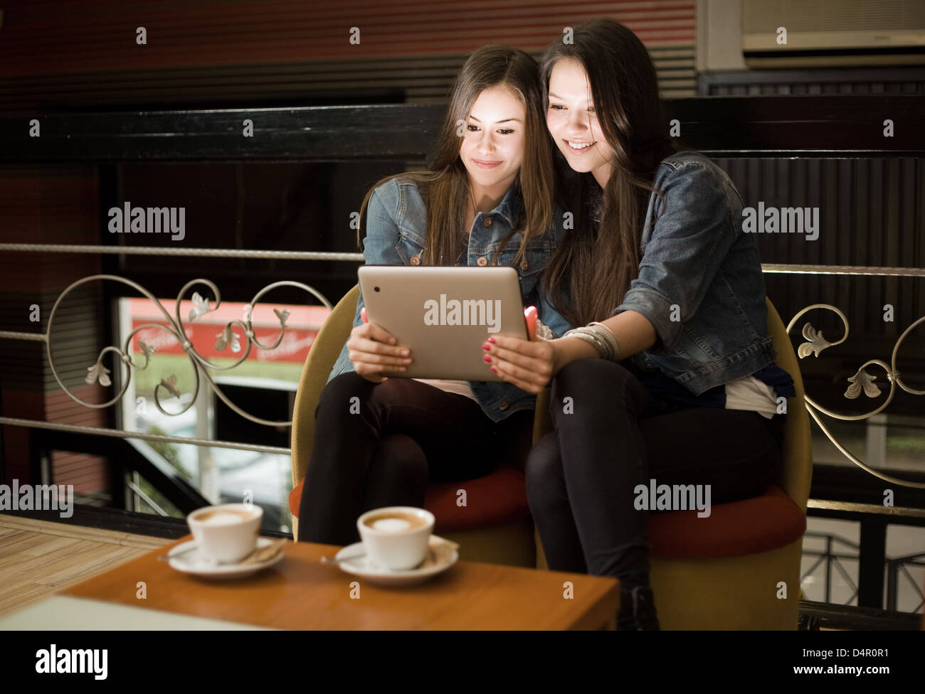 Deux belles jeunes filles de l'ordinateur tablette de partage. Banque D'Images