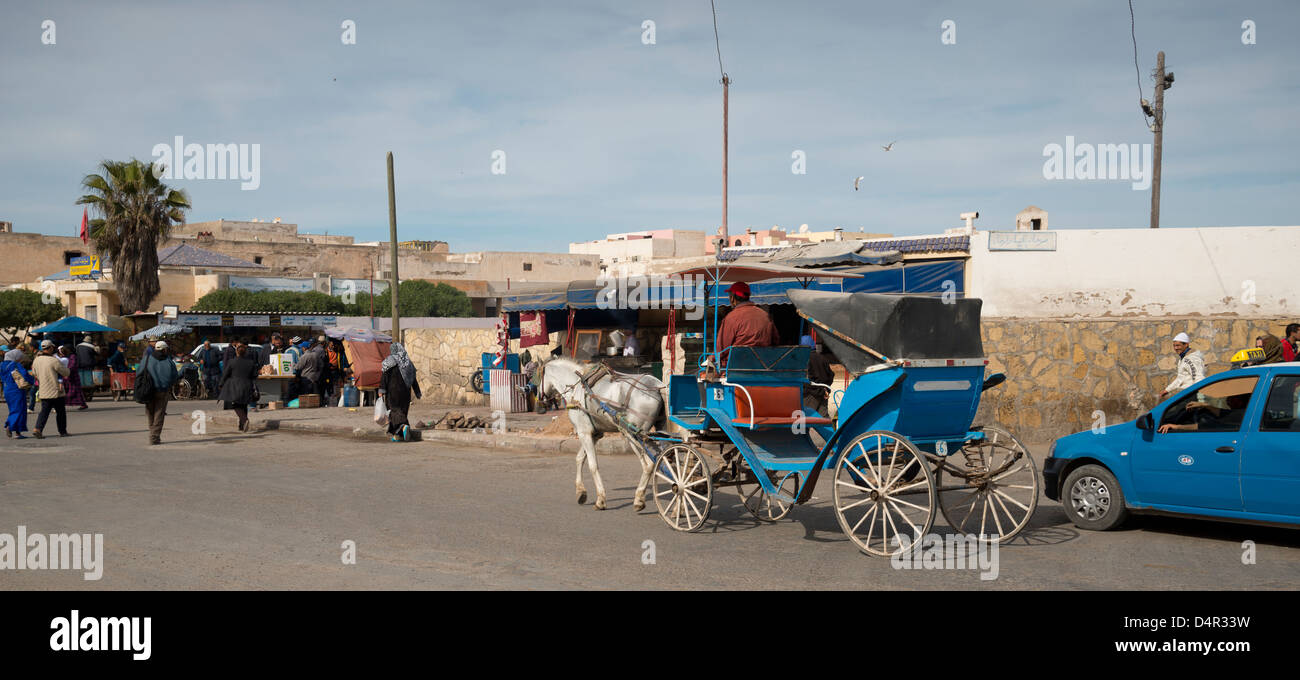 Rue animée à Essaouira, Maroc. Des taxis tirés par des chevaux, les gens et les voitures Banque D'Images