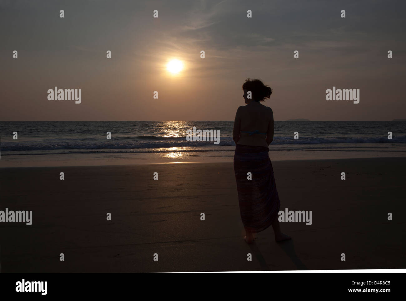 Situé sur Arossim Beach, Sud de Goa, Inde. Une femme donne sur la mer au coucher du soleil dans l'après-midi. Banque D'Images