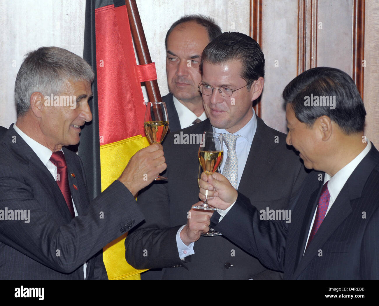 Karl-Theodor zu Guttenberg (2-R), le ministre allemand de l'économie, Vice-président chinois Xi Jinping (R) et Jürgen Hambrecht (L), Président de la Commission Asie-Pacifique de l'Allemagne ?s Business Association, clink lunettes à l'hôtel Adlon à Berlin, Allemagne, 12 octobre 2009. Le ministère chinois du commerce et le ministère allemand des Finances a signé un accord bilatéral sur l'échange de codes et de règles. Banque D'Images