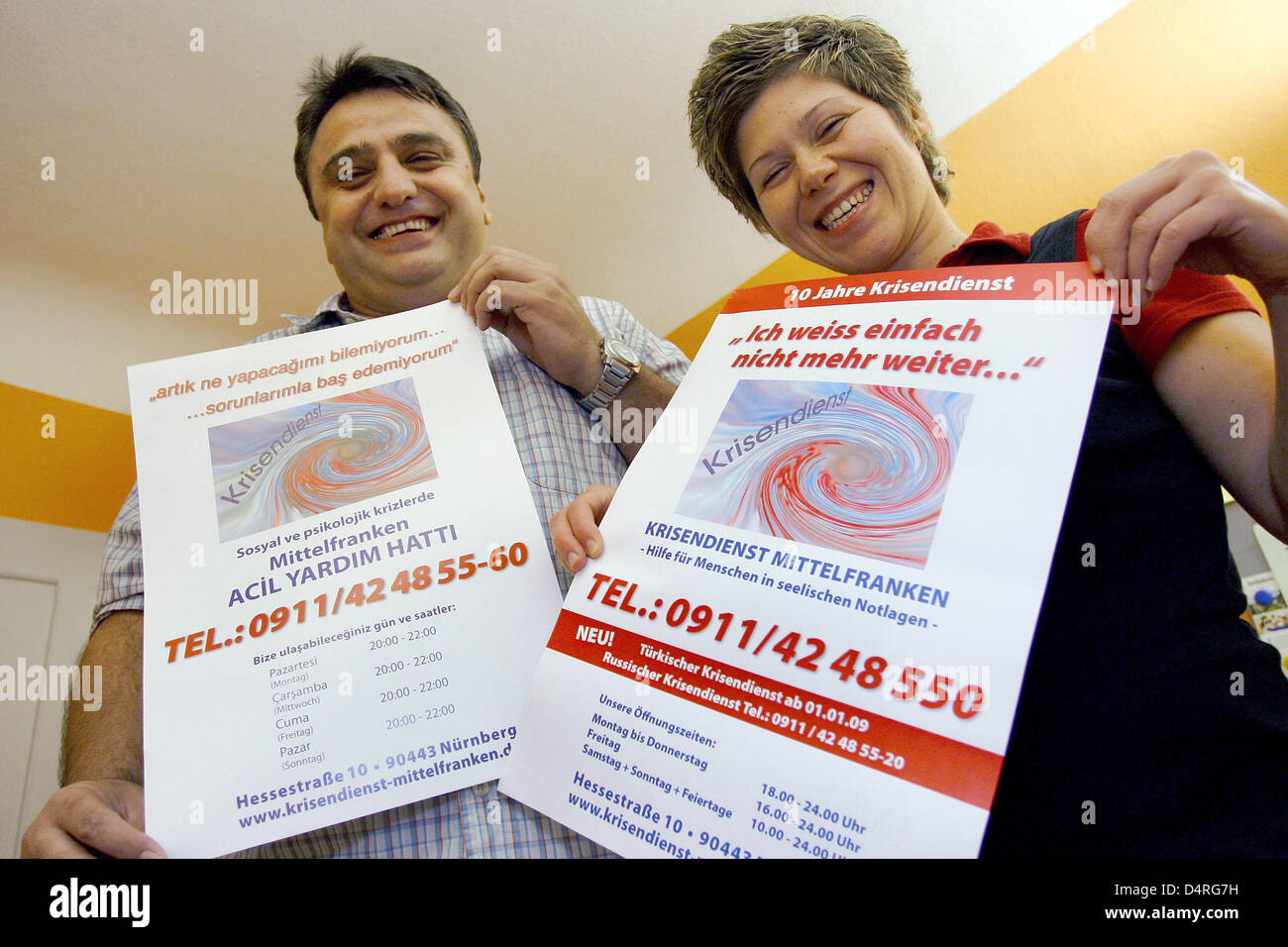 Yakub Keskin (L), coordinatot d'un service de crise de langue turque, et son personnel membre Yasemin Aykut (R) posent avec- allemand et turc-lecture des affiches à Nuremberg, Allemagne, 07 octobre 2009. Le coup de Nuremberg Allemagne ?s première crise de langue turque publique visant à aider quelque 100 000 personnes d'origine turque dans la région de Nuremberg décent. Photo : Daniel Karmann Banque D'Images