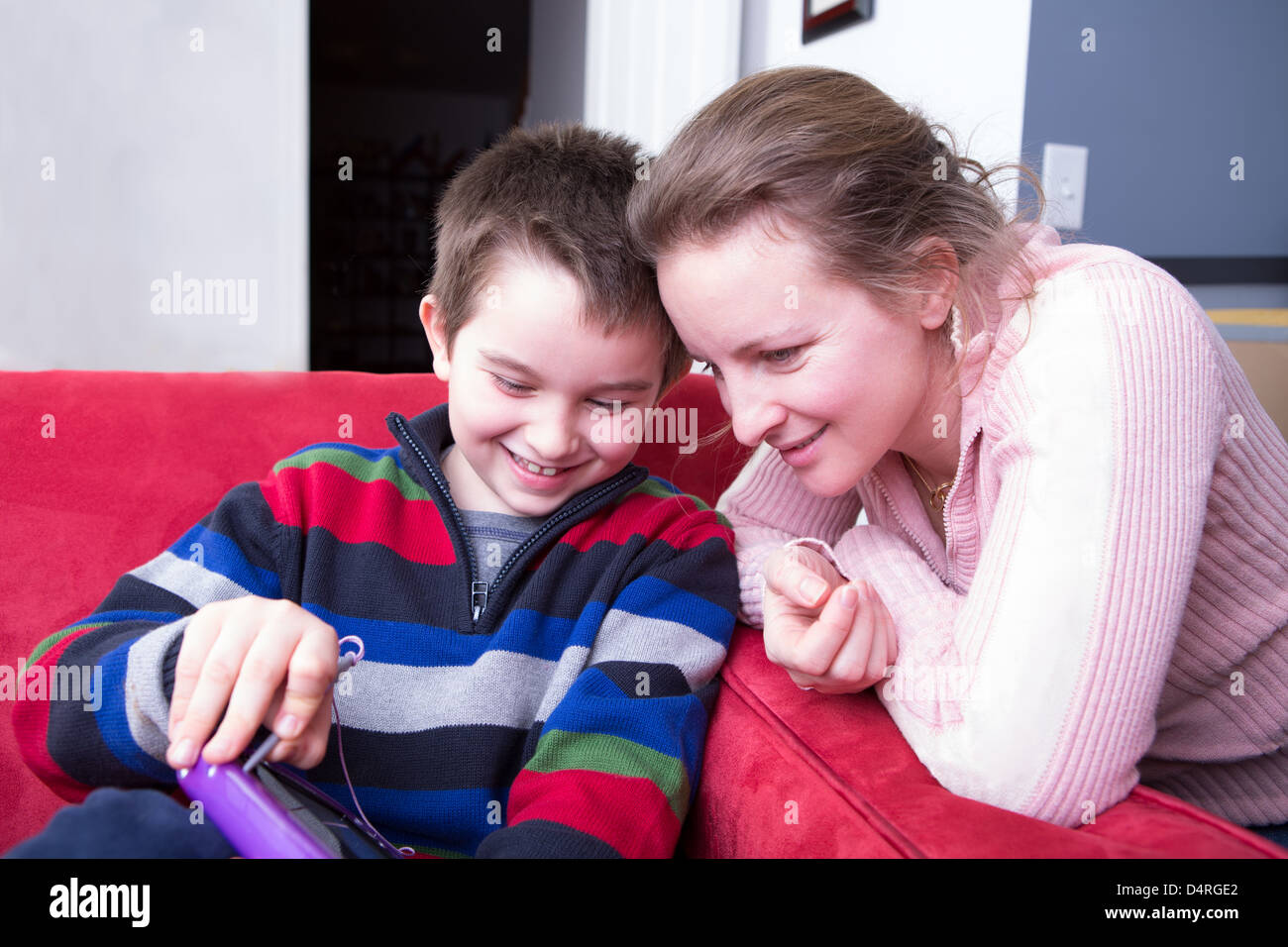 Mère et son fils à la recherche de la tablette. Il montre sa créativité heureusement alors qu'elle est en montrant son intérêt. Banque D'Images