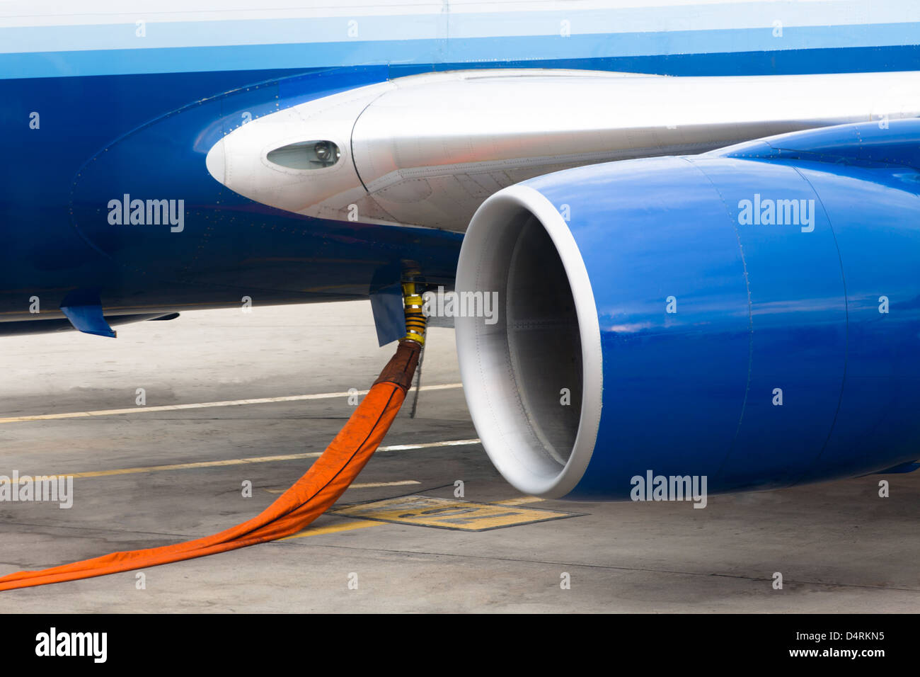 Le flexible d'Orange prêt à remplir les réservoirs de gaz naturel dans le kérosène d'un avion à réaction. Banque D'Images