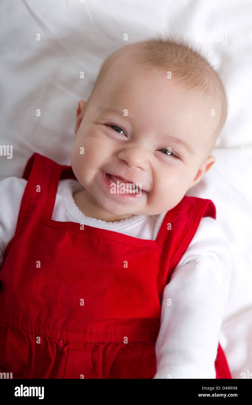 3 mois girl smiling sans crainte, en attendant ses dents et cheveux pour se développer. Banque D'Images