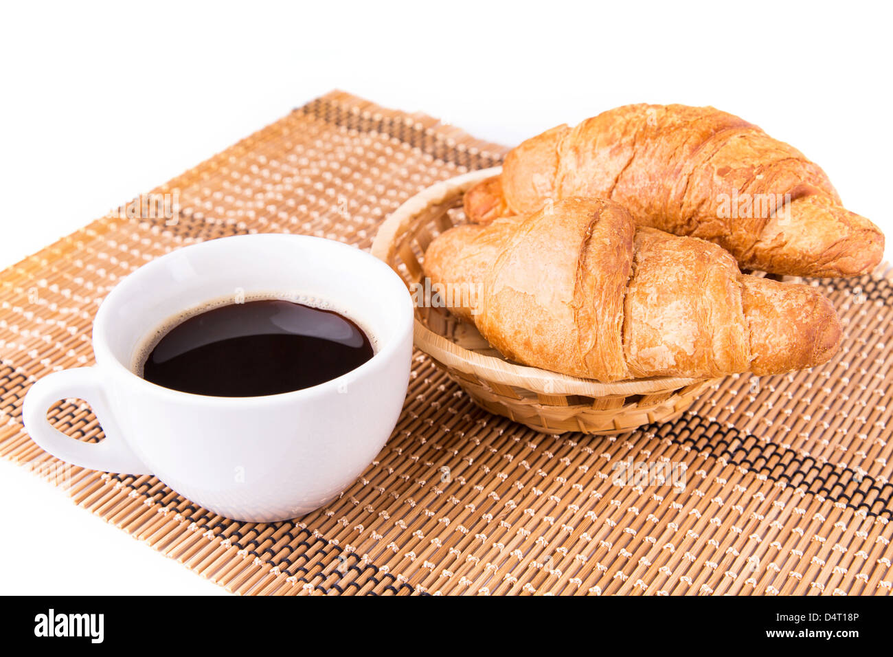 Frais et savoureux croissants français dans un panier et tasse de café servi isolé sur fond blanc Banque D'Images