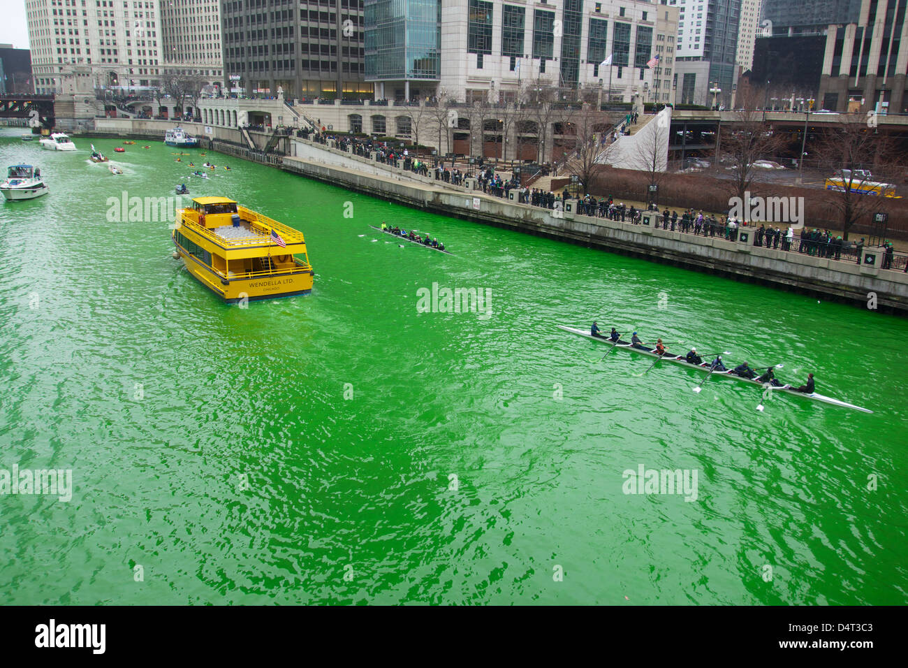 Un taxi d'eau de Chicago jaune contraste avec le vert de la rivière Chicago pour teint le jour de la Saint Patrick. Banque D'Images