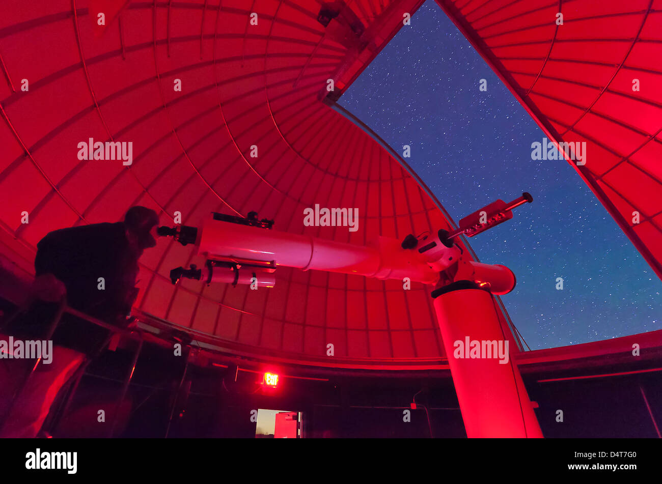 À l'intérieur de l'observatoire, un astronome fait des observations avec un grand télescope réfracteur au campus d'astronomie 3RF au Texas. Banque D'Images