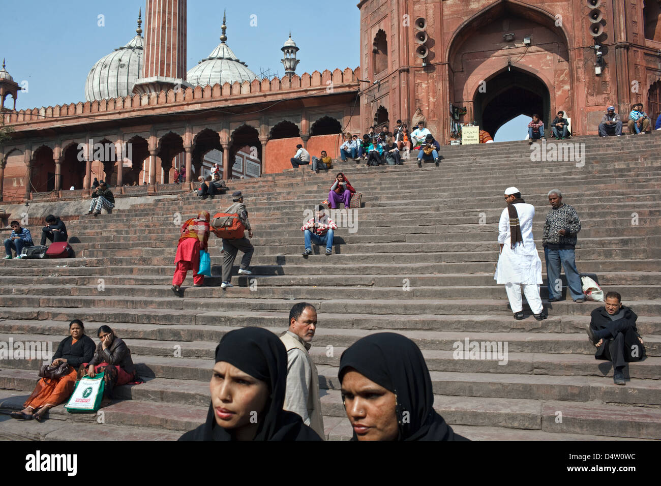 Les gens sur les marches à l'extérieur de la mosquée Jama Masjid dans la vieille ville de Delhi, Inde. Banque D'Images