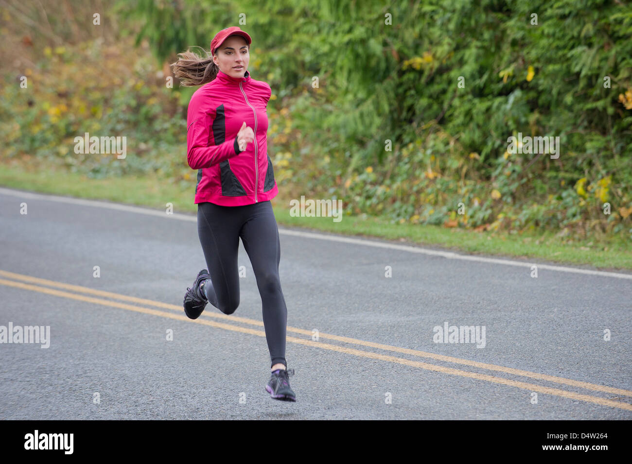 Woman running on rural road Banque D'Images