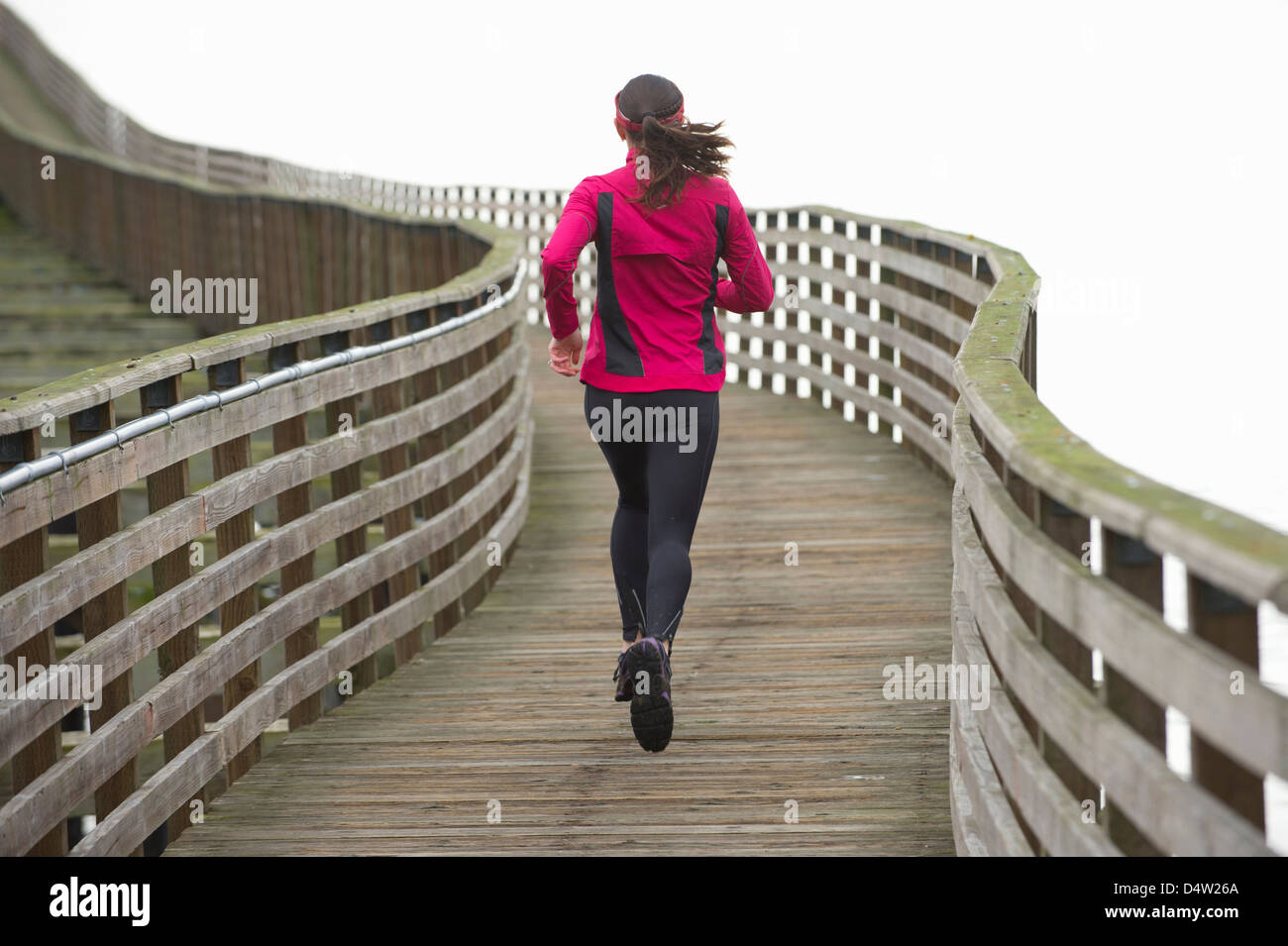 Woman running on wooden dock Banque D'Images