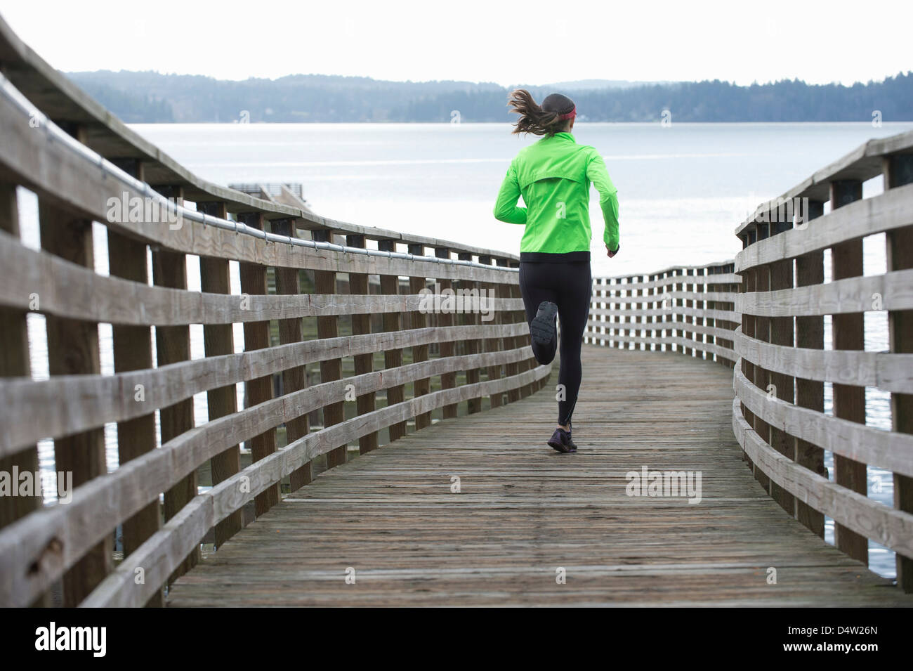 Woman running on wooden dock Banque D'Images