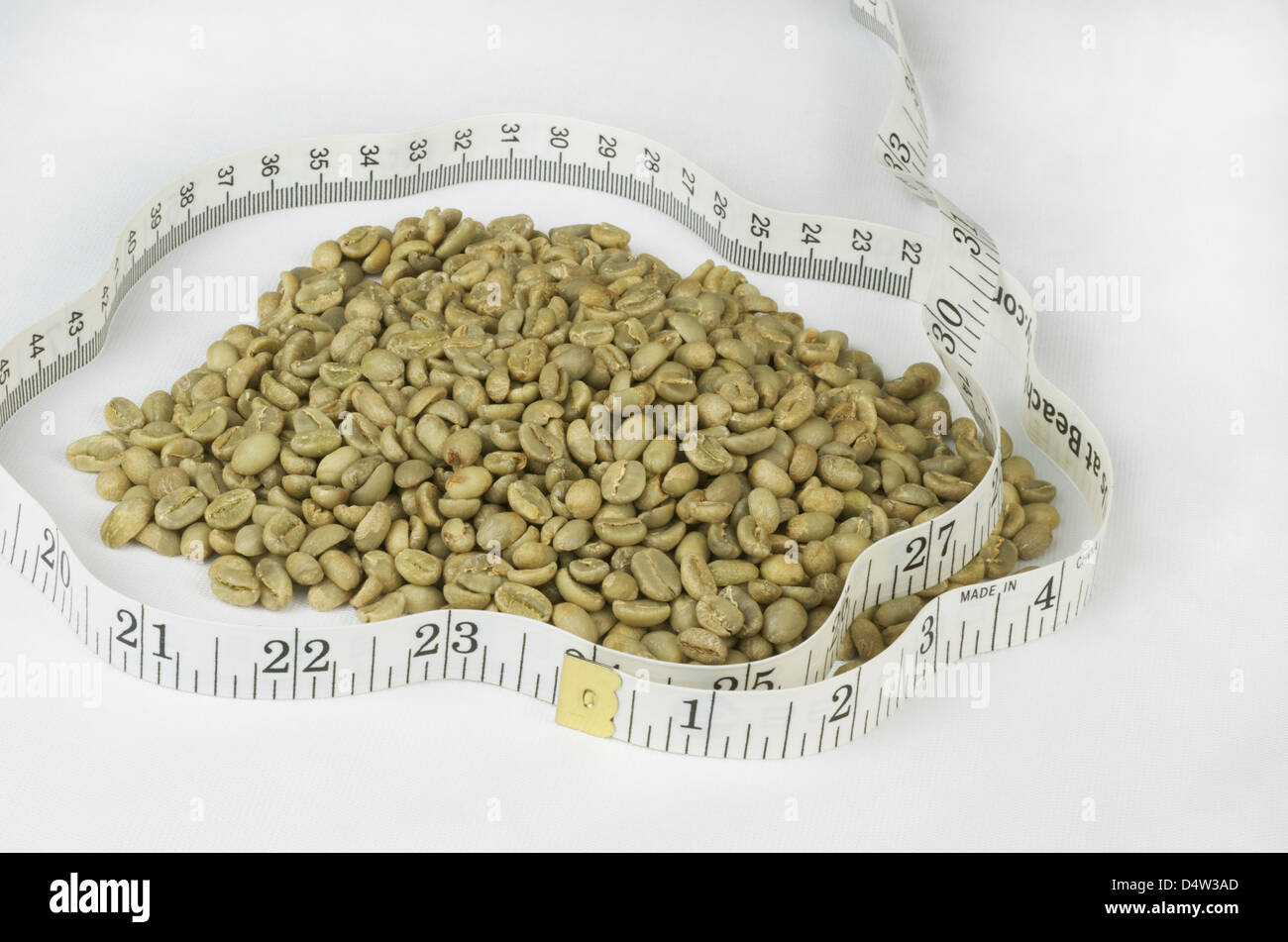 Les grains de café vert avec un ruban blanc qui les entourent, pour représenter la perte de poids Suppléments alimentaires dérivés de l'haricot. Banque D'Images