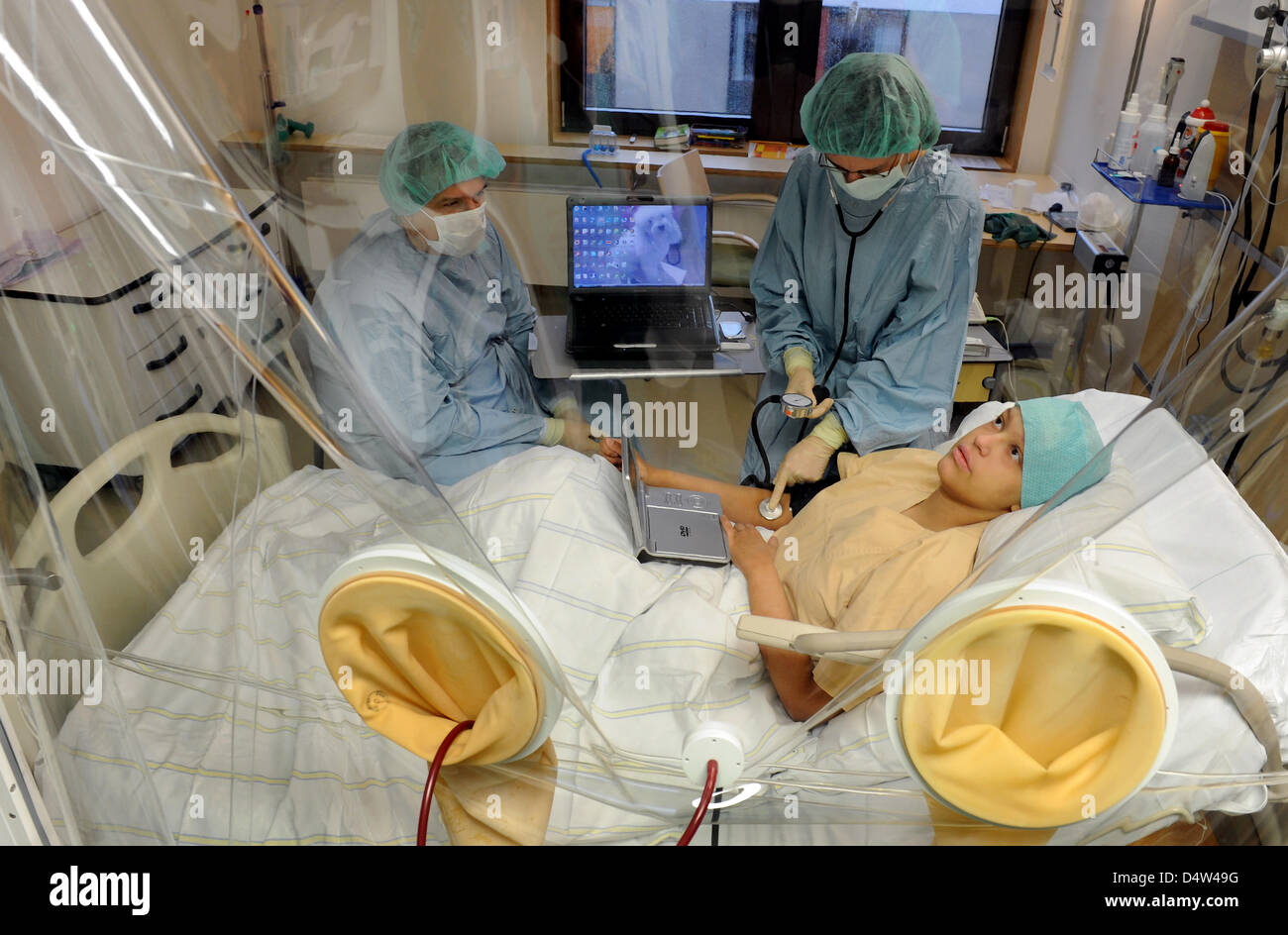 Ivonne infirmière (R) vérifie les signes vitaux de 14 ans, à côté d'Andreja patient serbe son père (L) dans l'hématologie et oncologie Ministère de l'José-Carreras-station pour la moelle épinière et d'une greffe de cellules souches de l'université de Leipzig, Allemagne, 11 décembre 2009. Andreja patient leucémie se trouve dans une salle blanche et recevront une greffe de cellules souches. La station a été trouvé Banque D'Images