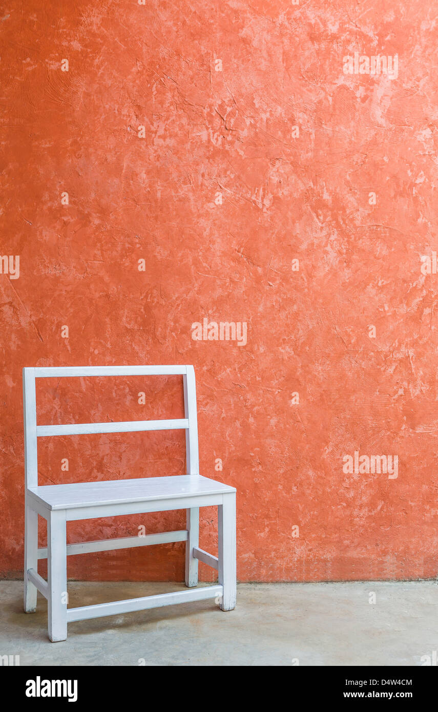 Chaise en bois blanc et couleur orange grunge wall Banque D'Images