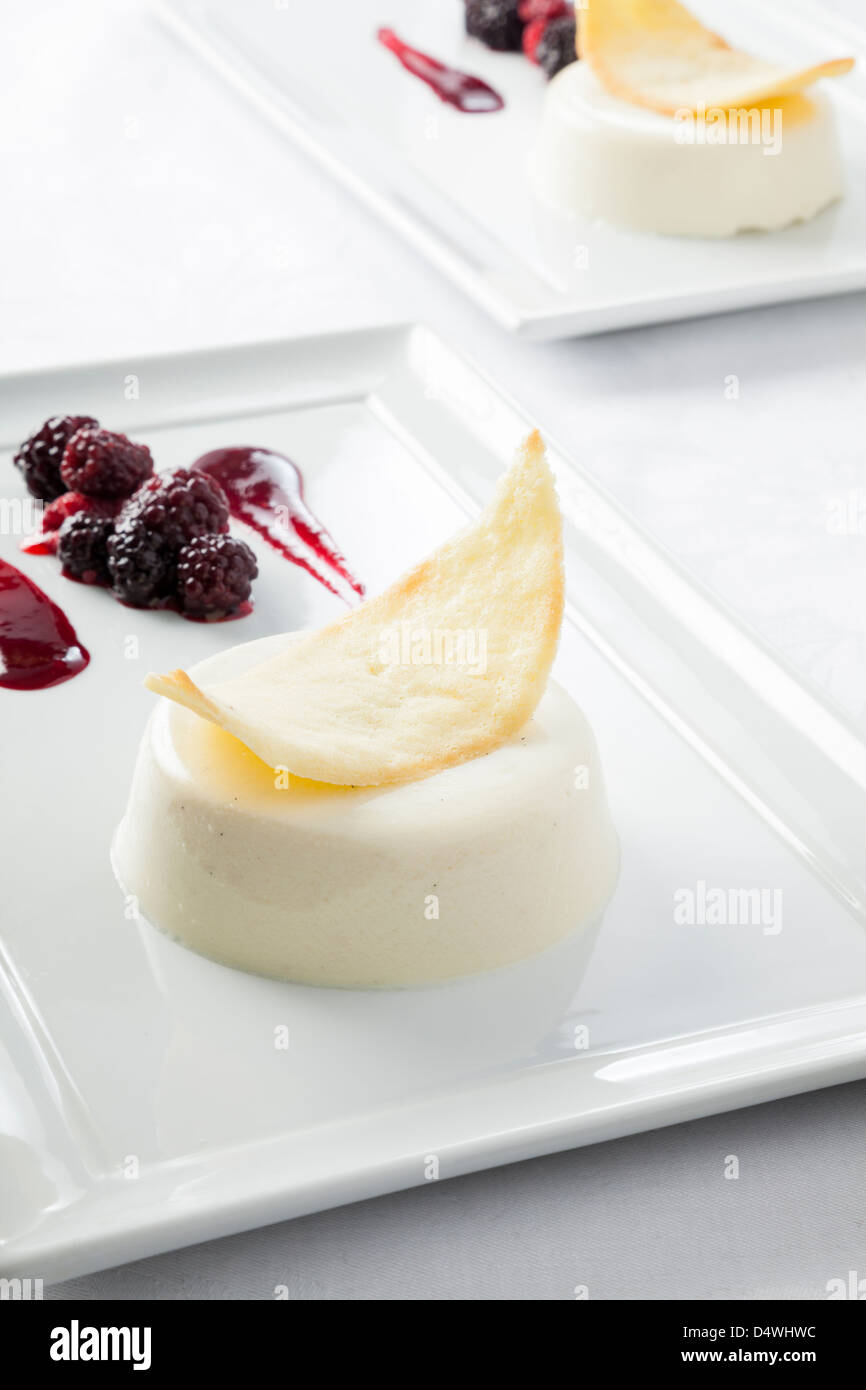 Panacotta vanille avec un mélange de fruits rouges et tuile au Banque D'Images