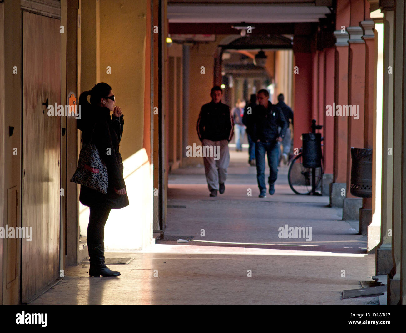 Les gens marcher dans une arcade à Bologne. Banque D'Images