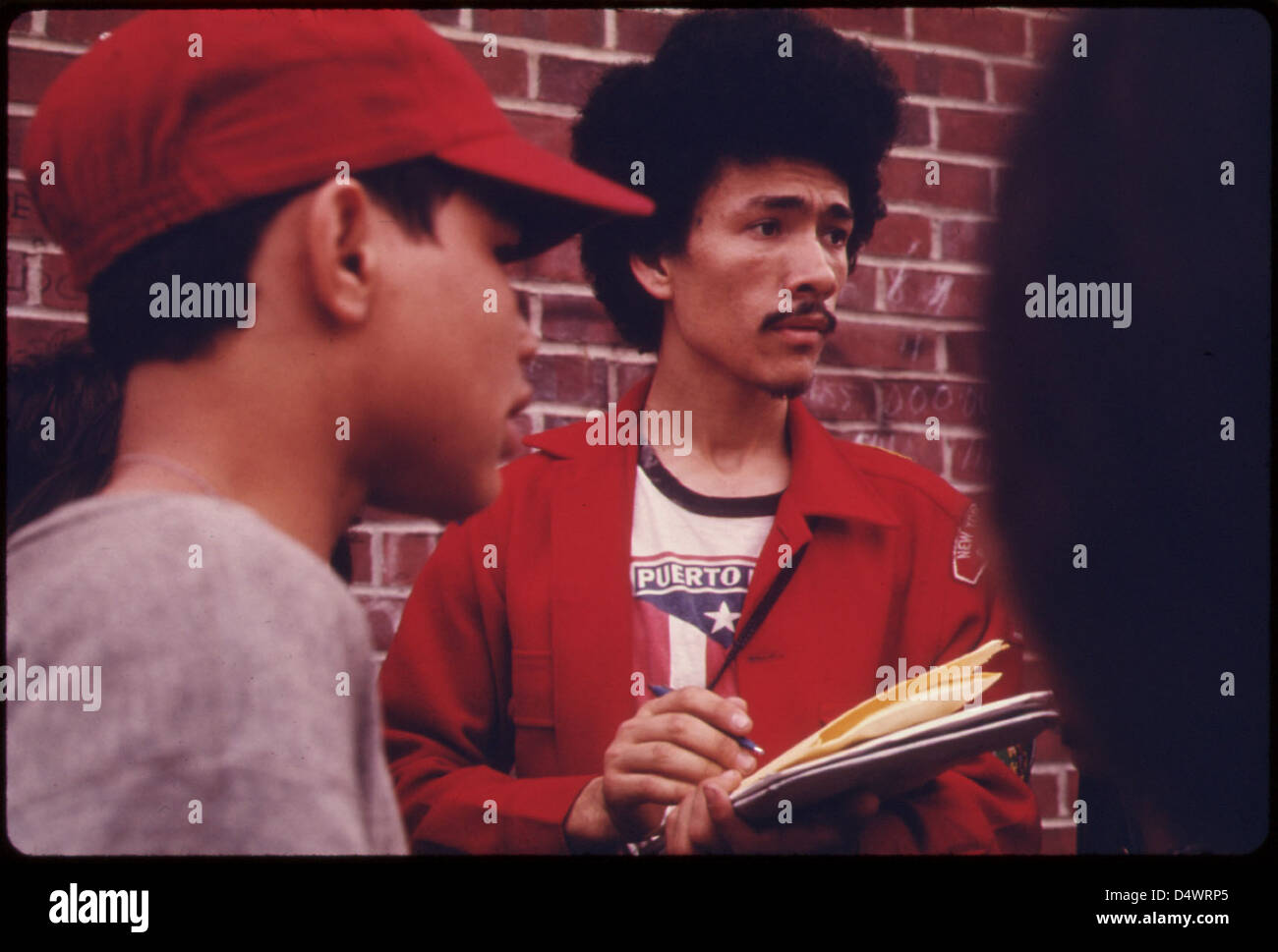 Cette photographie de 1974 montre un leader scout recrutant des jeunes latins dans le district de Bedford-Stuyvesant à Brooklyn, mettant en évidence l'engagement des jeunes et l'implication communautaire dans les zones urbaines. Banque D'Images