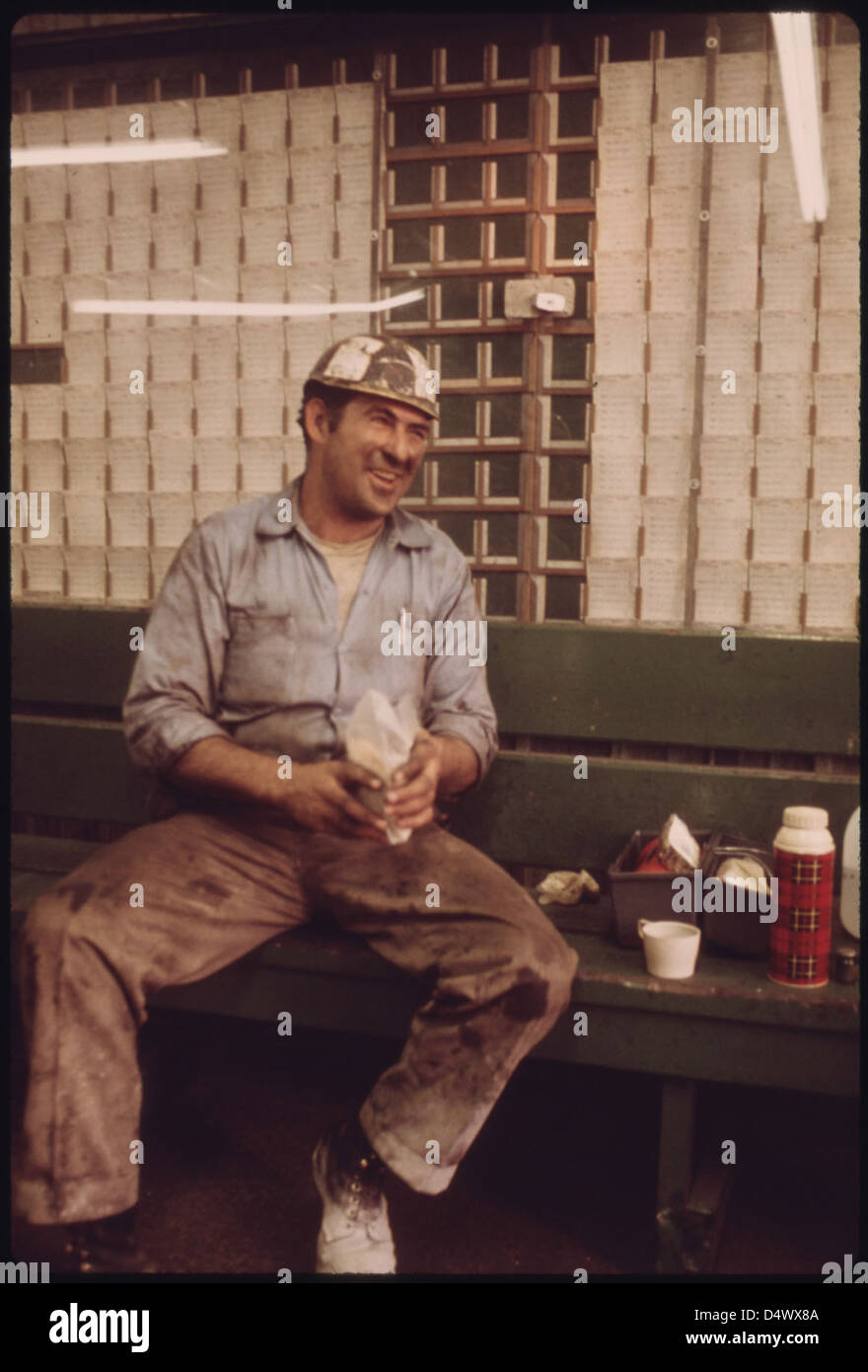 Le mineur diffuse son déjeuner sur un banc dans la salle de douche et de carte de temps de la mine no 3 de la Virginia-Pocahontas Coal Company, près de Richlands, en Virginie. Il transporte des équipements dans la mine pendant son quart de travail 04/1974 Banque D'Images