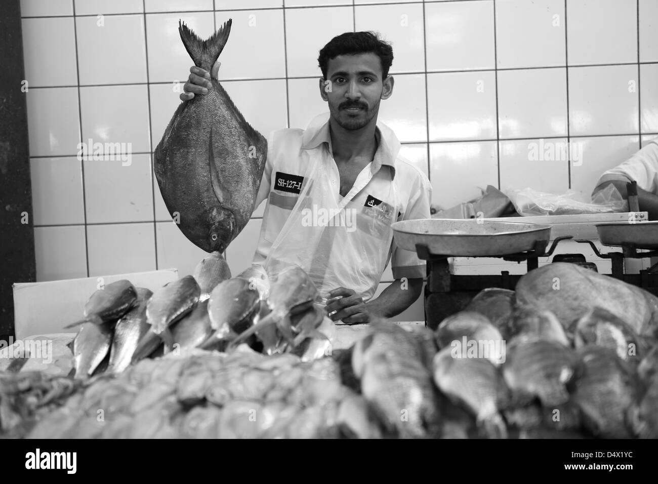 Man holding up du poisson au marché, Dubai, Émirats Arabes Unis Banque D'Images