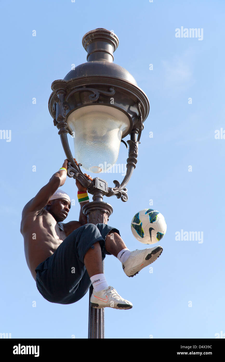 Artiste de performance acrobatique sur une vieille lampe à gaz sur la colline du Sacré Coeur de Montmartre - Paris Banque D'Images