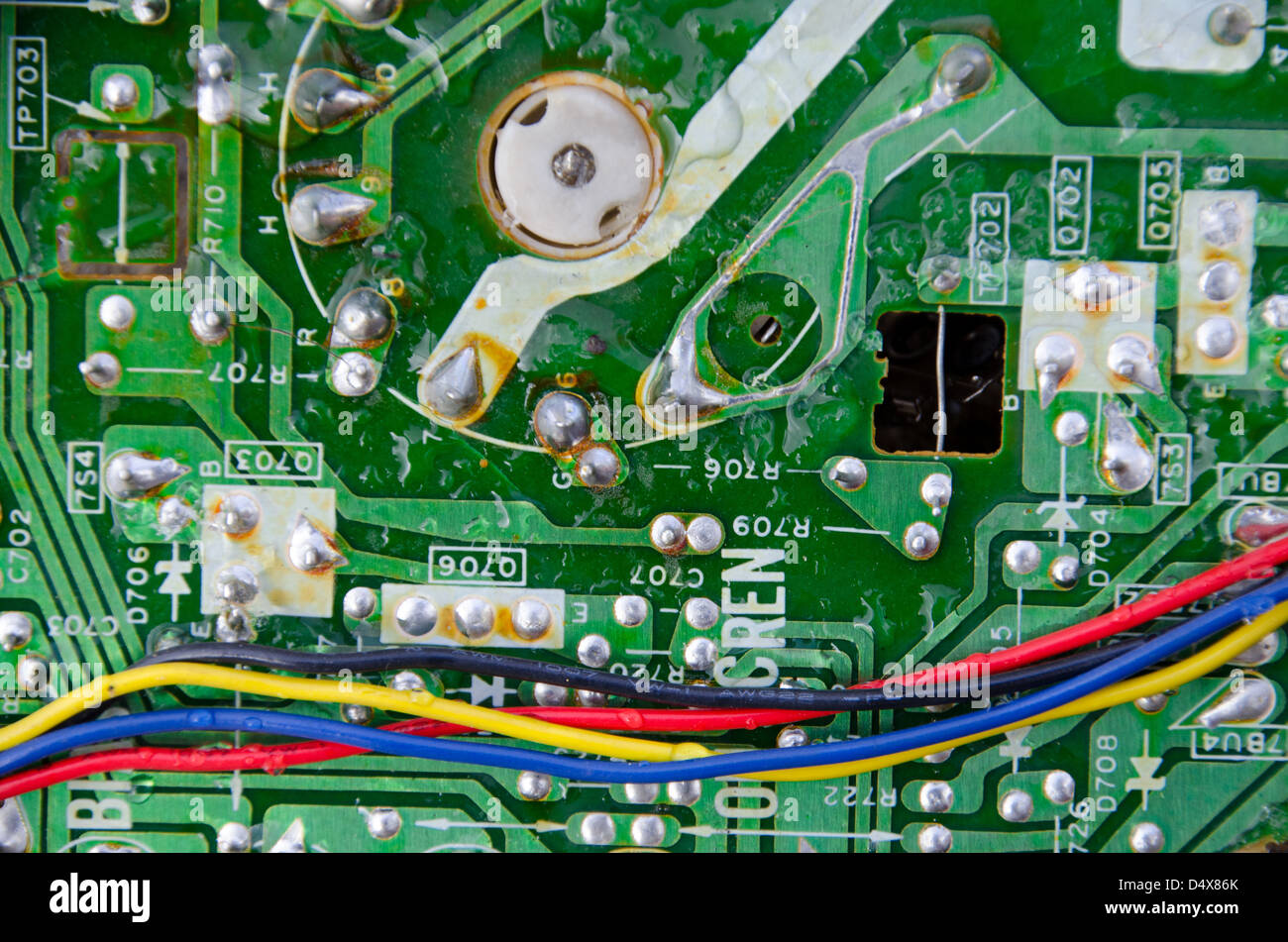 Texture de fond de la technologie d'un métal vert carte à circuits imprimés, rouge, jaune, bleu et noir avec des gouttes de pluie Banque D'Images