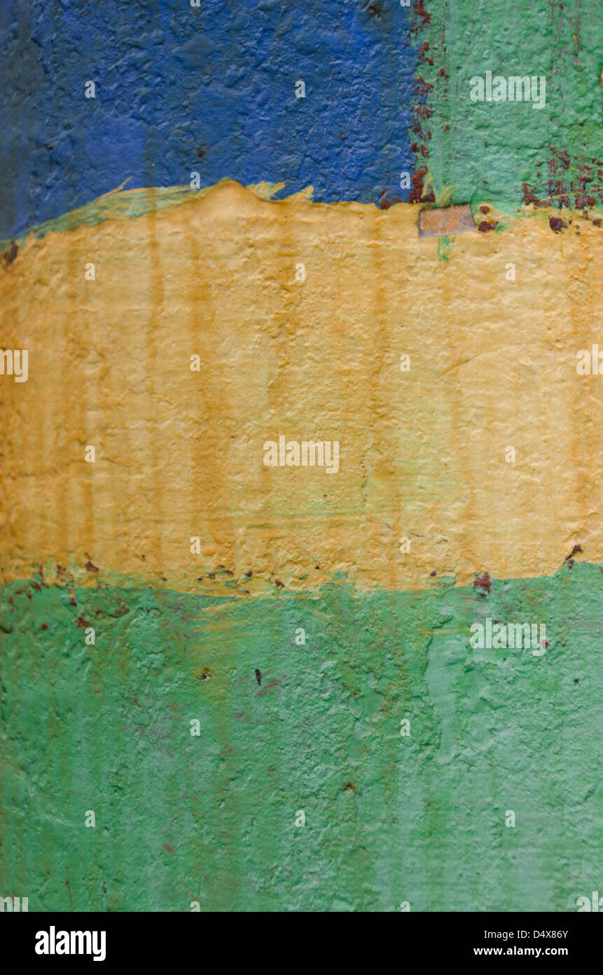 Artsy peint texture de fond urbain avec bandes de bleu, jaune et vert de la peinture sur un poteau téléphonique en bois Banque D'Images