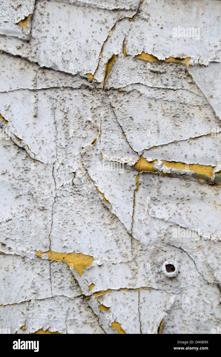 Texture de fond urbain graveleux avec 12.2005 et peeling peinture blanche couvrant un mur de ciment jaune Banque D'Images