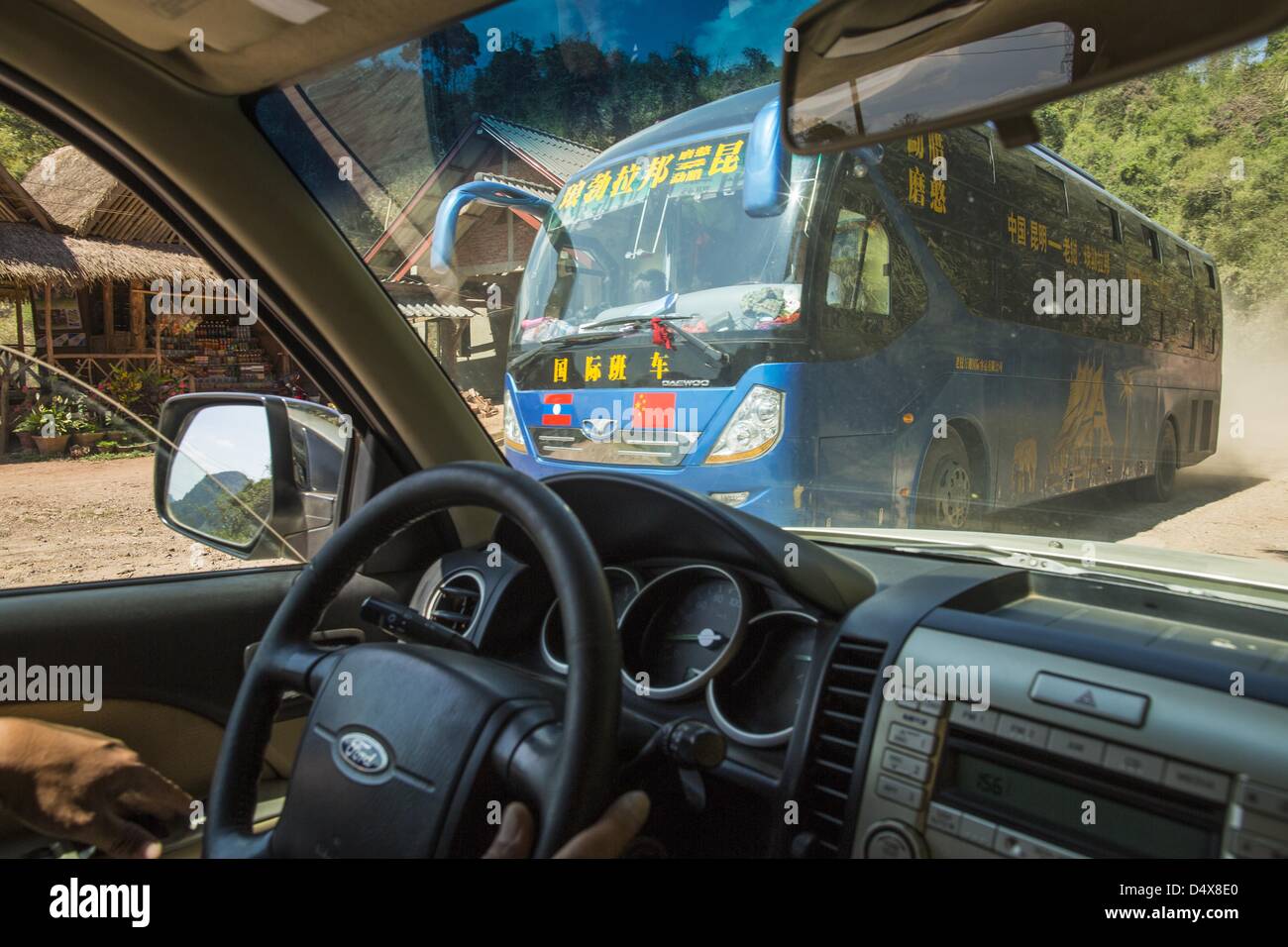 12 mars 2013 - interdiction d'Oudomxay, Namthip, Laos - Un bus de passagers chinois durs au sud sur la route 13 dans les régions rurales du Laos vers Luang Prabang. Comme l'économie de la Chine et son rôle sur la scène mondiale élargit le rôle de la Chine en Asie du Sud-Est est également de plus en plus évident. Au Laos, à la frontière de la province du Yunnan dans le sud de la Chine, la Zone économique spéciale en Boten est essentiellement une enclave chinoise, des entreprises appartenant à des Chinois dominent la région. Il y a un petit magasin chinois utilisé à Oudomxay, à environ 100 kilomètres de la frontière. La Chine contribue à l'amélioration des routes du Laos, et est en pourparlers pour apporter un spe Banque D'Images