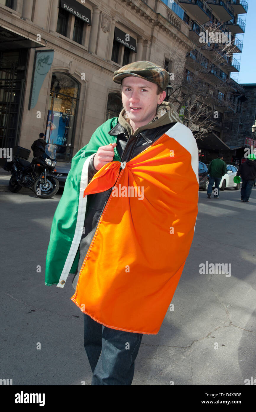 Jeune homme drapé dans un drapeau irlandais à la parade de la St Patrick. Banque D'Images