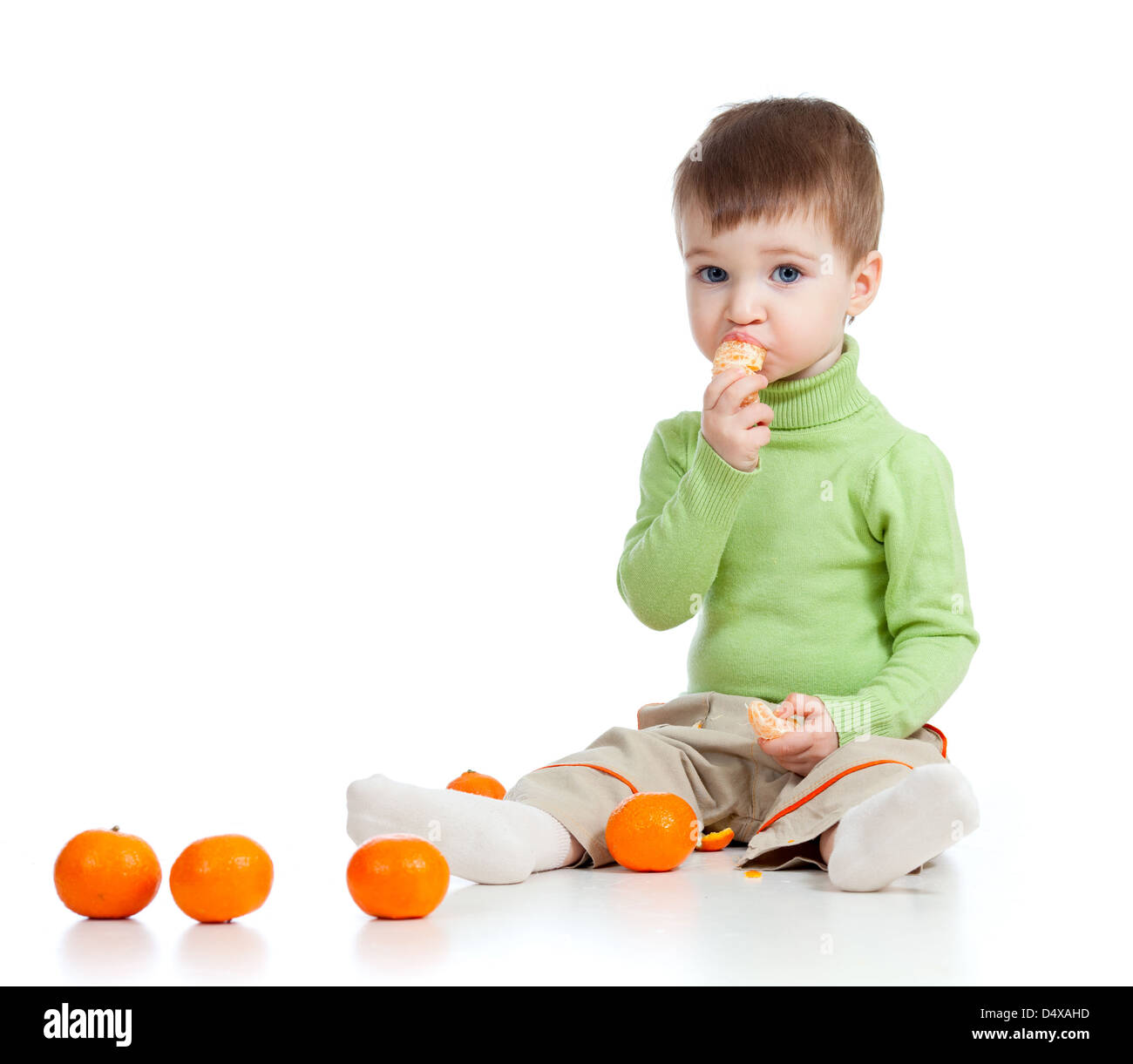 L'enfant drôle de manger des fruits sur fond blanc Banque D'Images