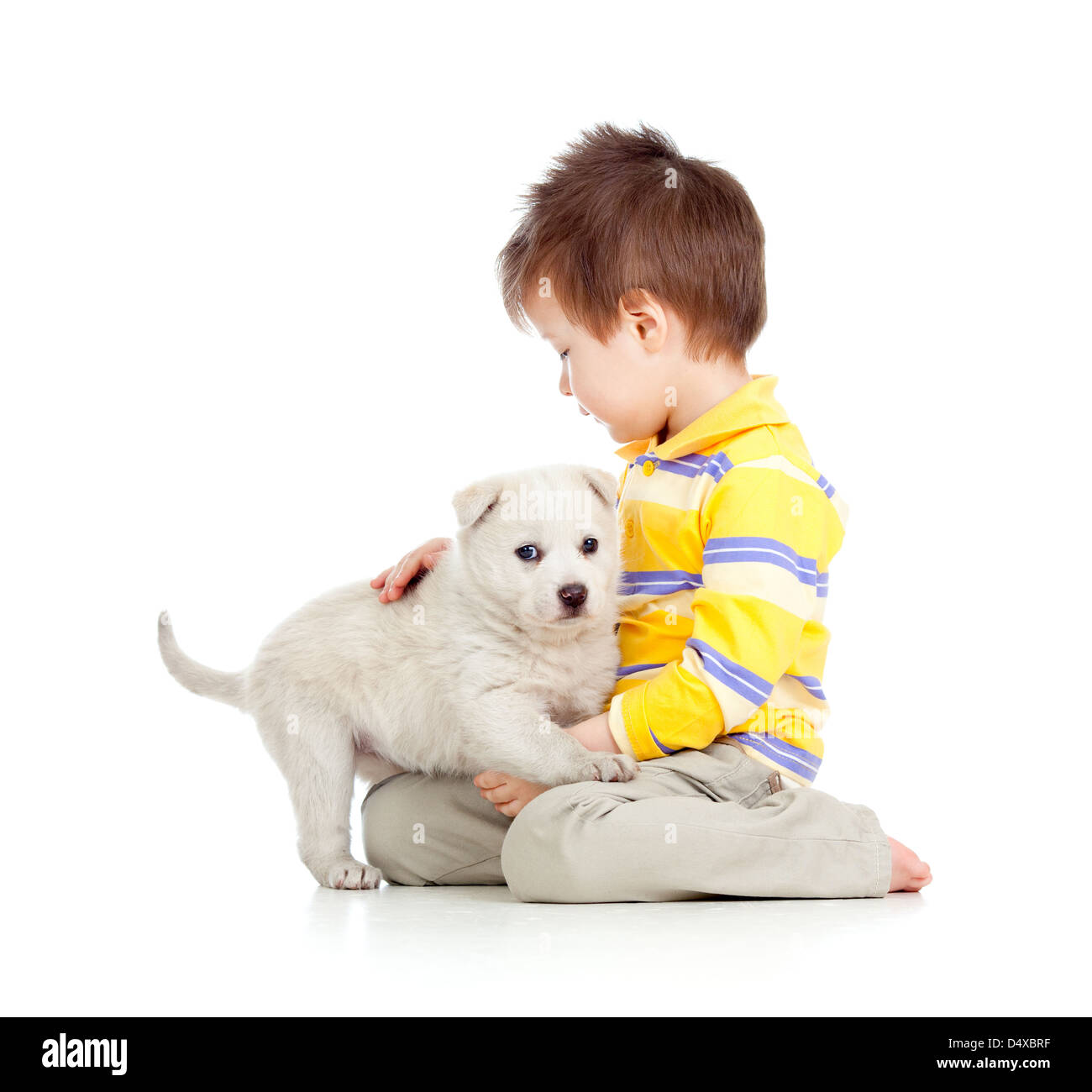 Kid hugging chiot sur fond blanc Banque D'Images