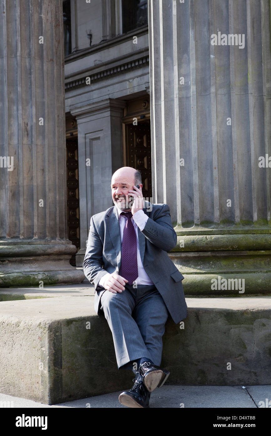 L'homme d'affaires à l'aide d'une émission d'un appel téléphonique en face de GoMA Glasgow Banque D'Images