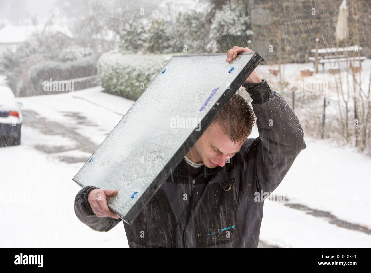 Vitriers exerçant son activité sous une sous-fenêtre dans la neige après leur van est resté coincé sur une colline raide, Ambleside, Lake District, UK. Banque D'Images