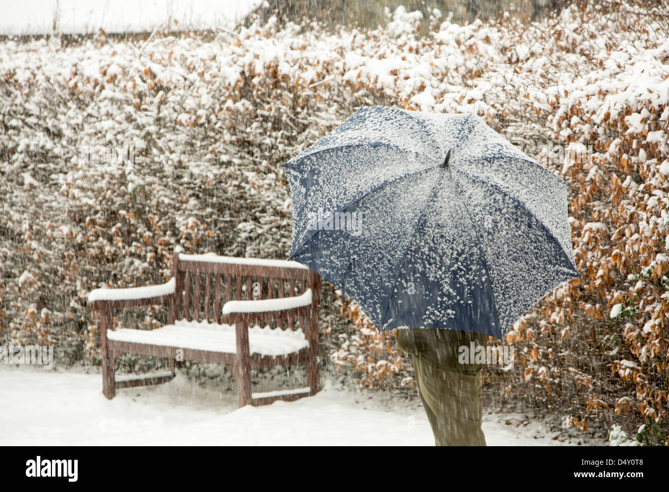 Un homme sous un parapluie dans la neige, Ambleside, Lake District, UK. Banque D'Images