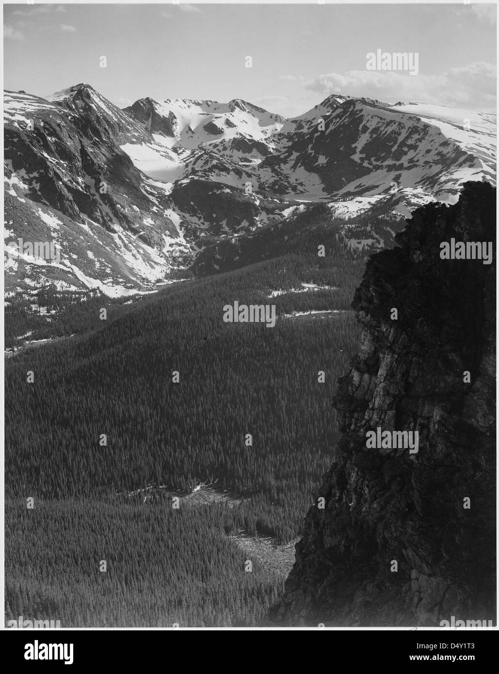 Cette photographie d'Ansel Adams capture une scène montagneuse enneigée dans le parc national des montagnes Rocheuses, Colorado, mettant en valeur la beauté naturelle étonnante de la région en noir et blanc. Banque D'Images