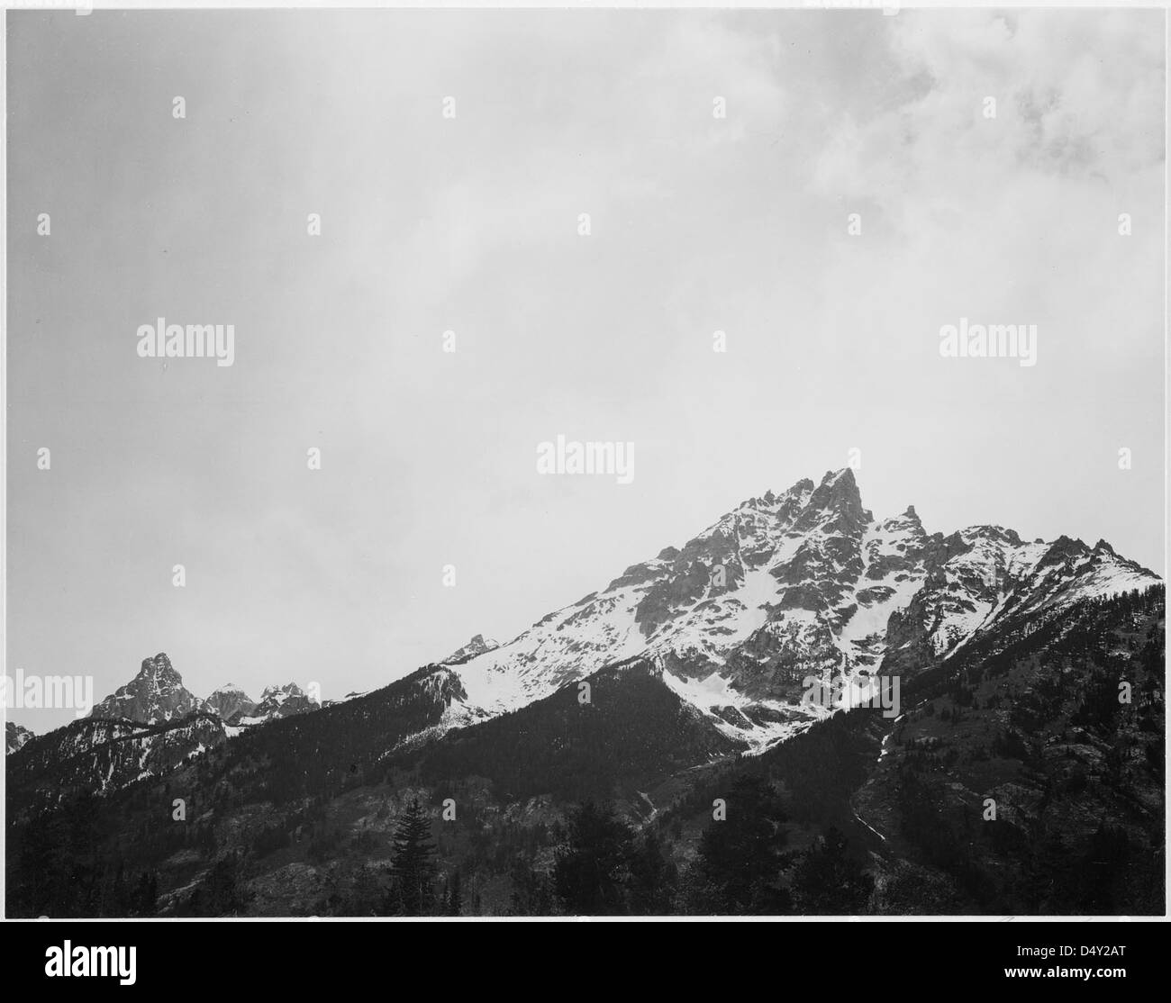 Pic enneigé dans le parc national de Grand Teton, Wyoming, photographié par Ansel Adams. Cette image en noir et blanc capture la beauté étonnante des grands Tétons en hiver. Banque D'Images