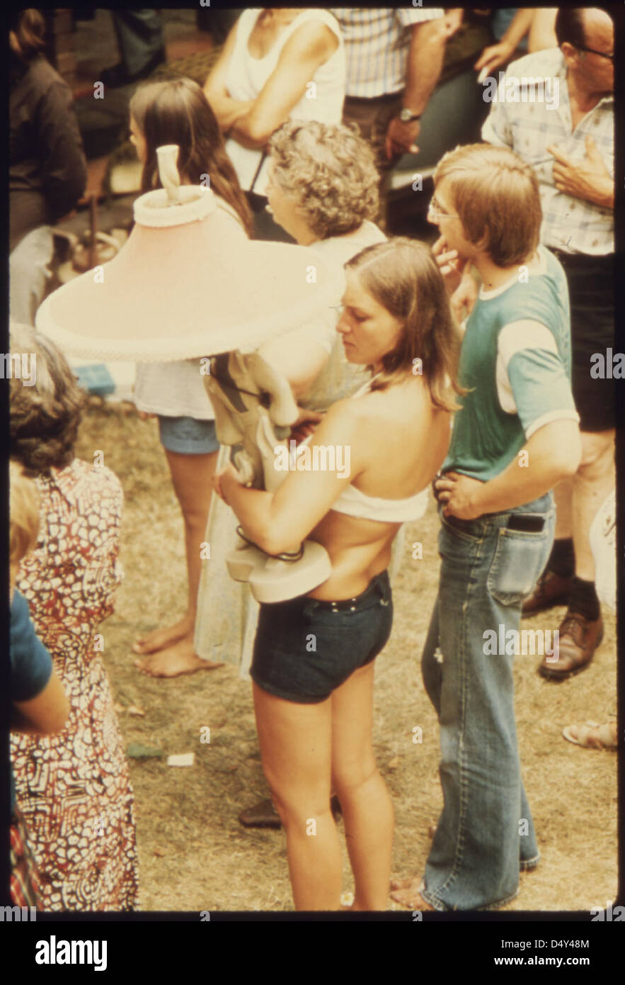 Un public à une vente aux enchères d'articles ménagers à New Ulm, Minnesota, généralement tenue en été pour vendre des biens de personnes retraitées déménageant dans des appartements ou de ceux qui sont décédés. Cette photo fait partie du projet DOCUMERICA documentant la vie américaine dans les années 1970 Banque D'Images