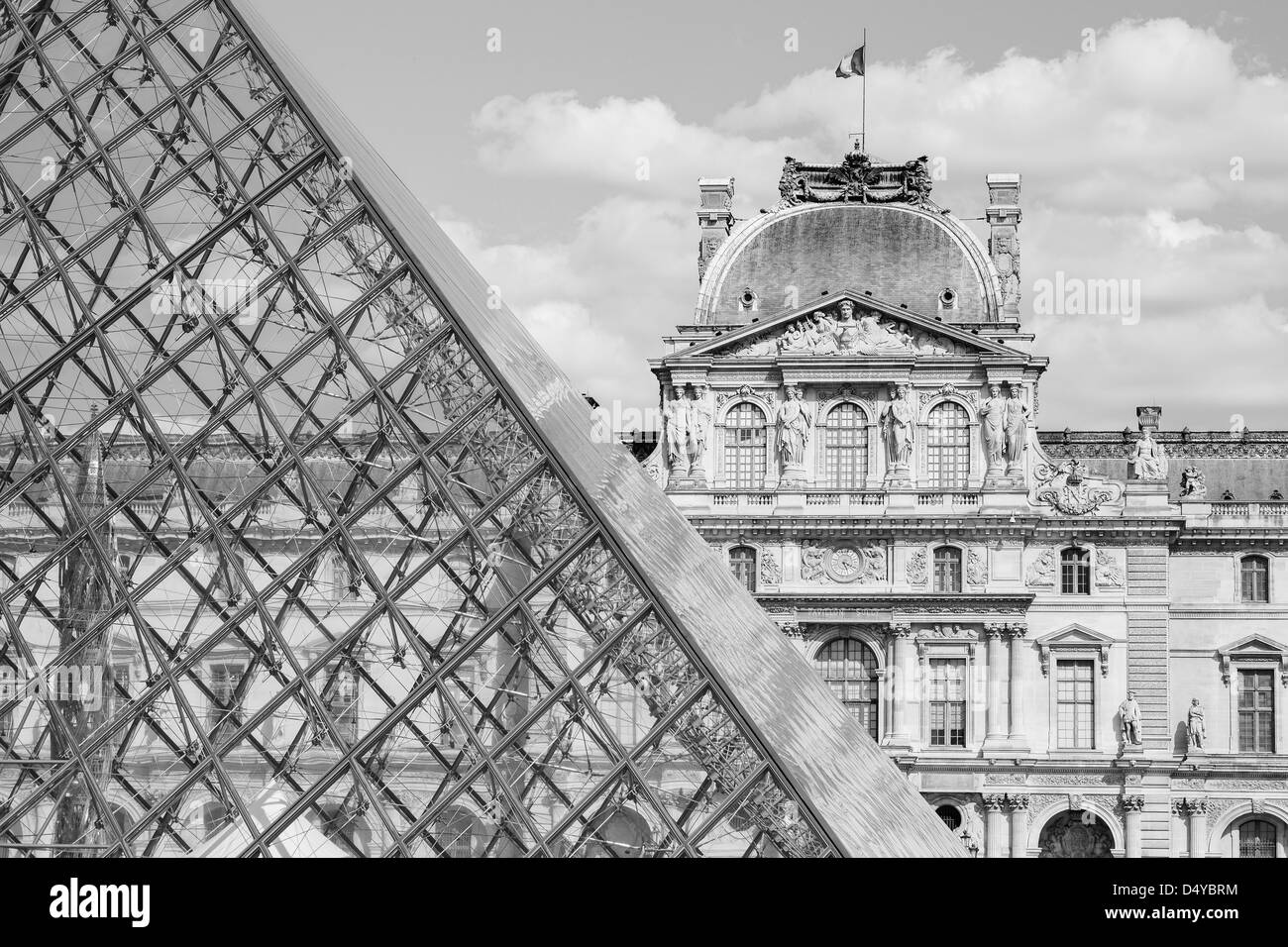 La Louvre à Paris tourné en noir et blanc avec la pyramide de verre qui les bullding traditionnels Banque D'Images